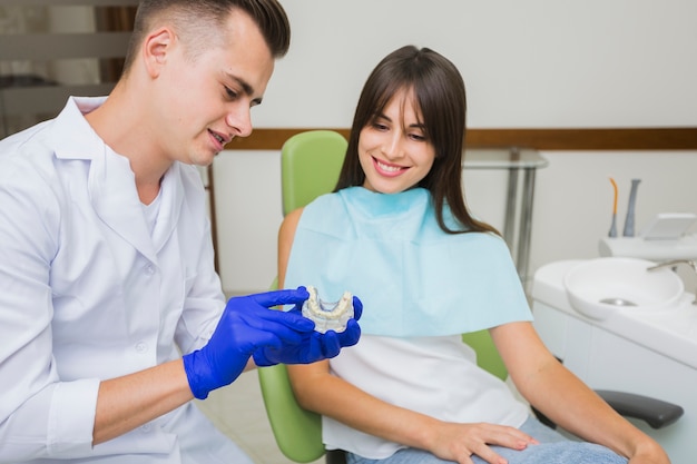 Foto dentista e paziente guardando protesi