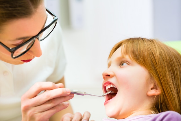 Dentist practicing with child in dental surgery 