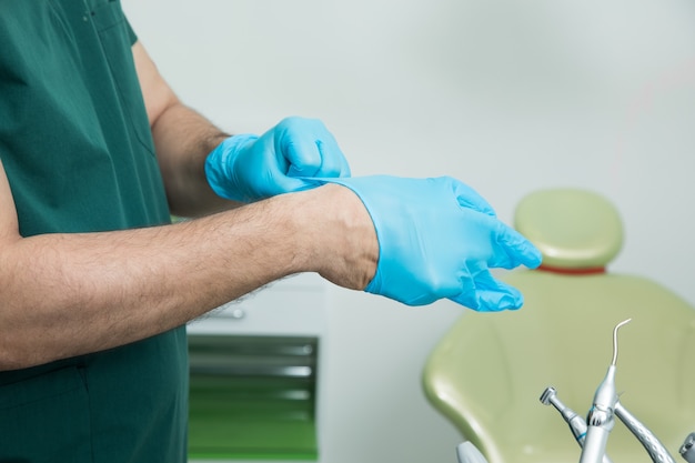 Il dentista indossa i guanti prima del lavoro