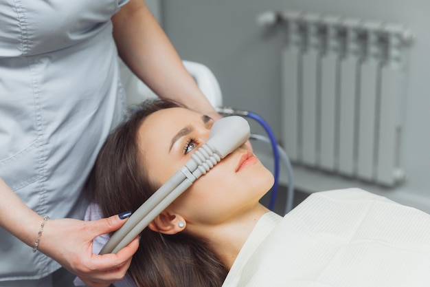 Dentist puts inhalation sedative mask on his patient