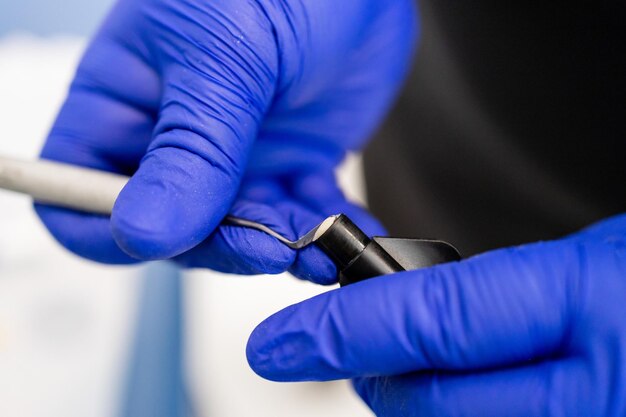 Dentist putting dental plugger into composite resins vial Composite filling material