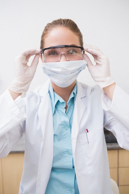 Dentist putting on her protective glasses