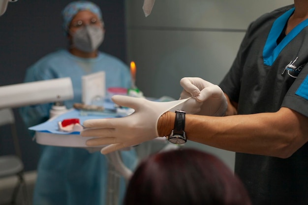 Dentist putting on latex gloves