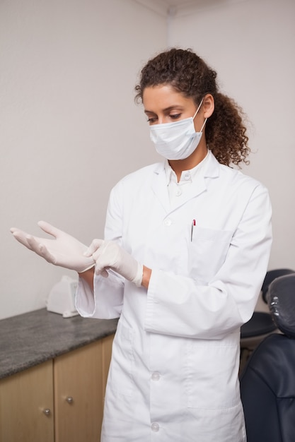 Photo dentist putting on surgical gloves