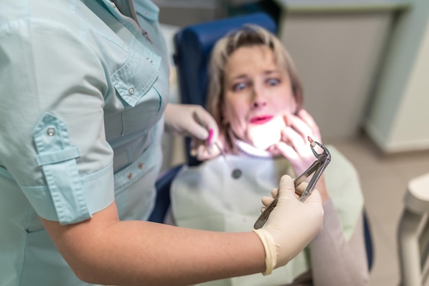 歯科医は歯科医院で歯の患者を取り除きます