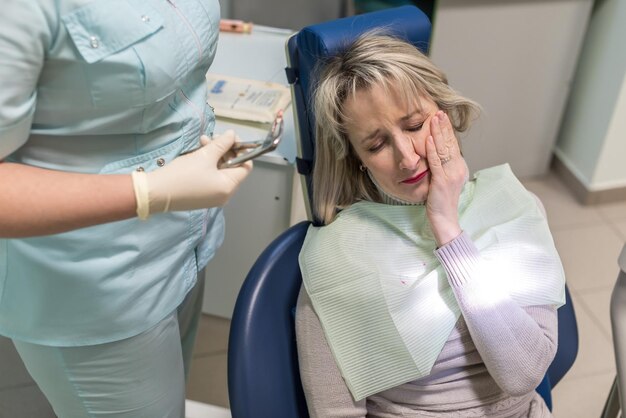 Photo dentist removes the tooth patient at the dental clinic