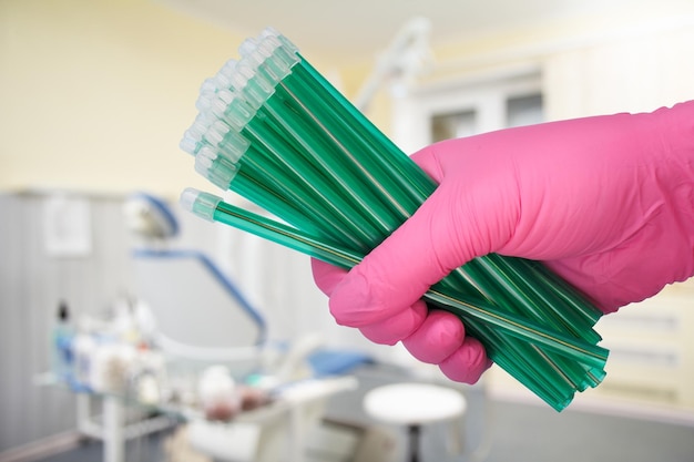 Dentist's hand in glove with saliva ejectors