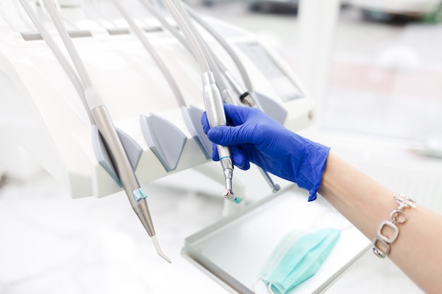 dentist’s hand takes one of the many drills. dental equipment concept