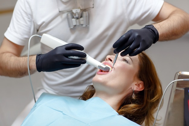 The dentist scans the patient's teeth with a 3d scanner.