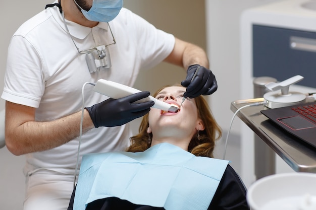 The dentist scans the patient's teeth with a 3d scanner.