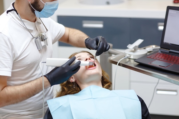 The dentist scans the patient's teeth with a 3d scanner.