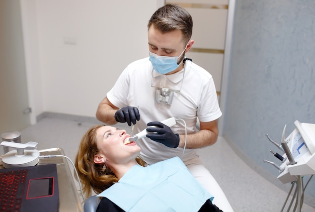 The dentist scans the patient's teeth with a 3d scanner.