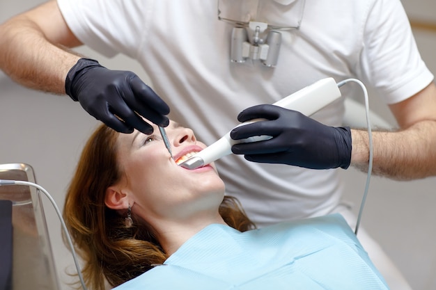 The dentist scans the patient's teeth with a 3d scanner.