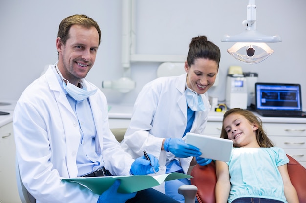 Dentist showing digital tablet to young patient