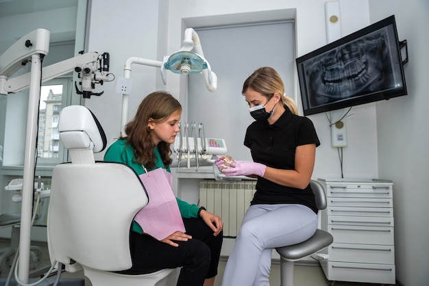 Dentist showing how to brush your teeth on jaws model to patient in dental clinic. healthcare