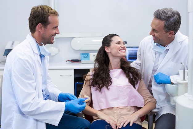 Dentist showing model teeth to patient