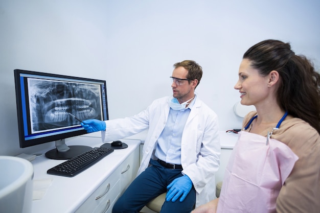 Foto dentista che mostra una radiografia dei denti al paziente femminile