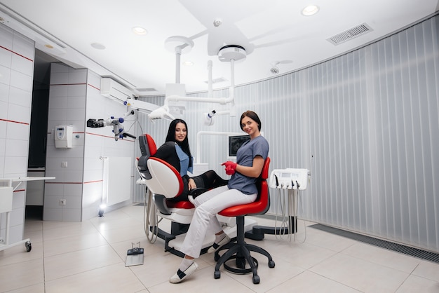 The dentist shows a picture of the patient's teeth and tells the necessary treatment. Dentistry, health.