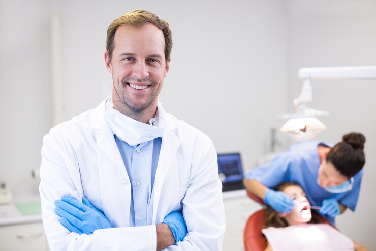 Photo dentist standing with arms crossed in clinic