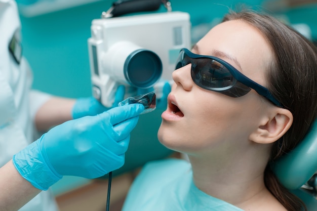 Dentist takes jaw xray Patient in dental chair