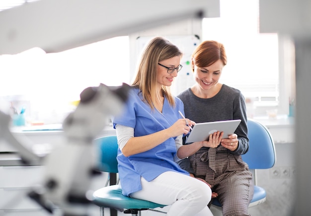 Photo a dentist talking to woman in dentist surgery a dental checkup