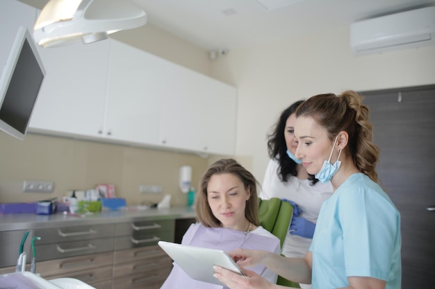 A dentist talks to a patient in a dental office.