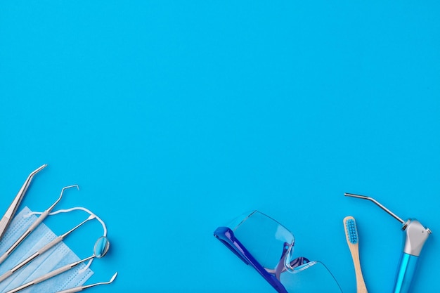 Photo dentist tools over blue background top view