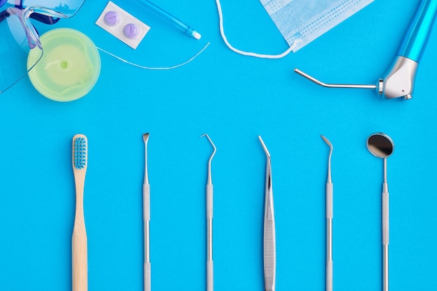 Dentist tools over blue background top view