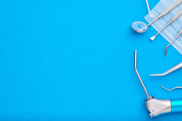 Photo dentist tools over blue background top view