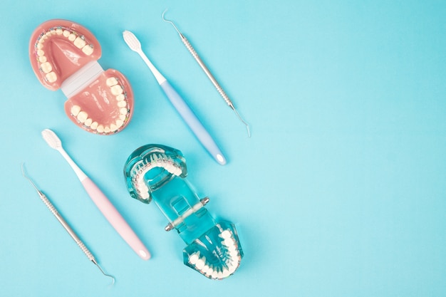 Dentist tools and orthodontic on the  blue background, flat lay, top view.