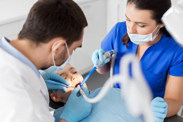 Photo dentist treating kid teeth at dental clinic