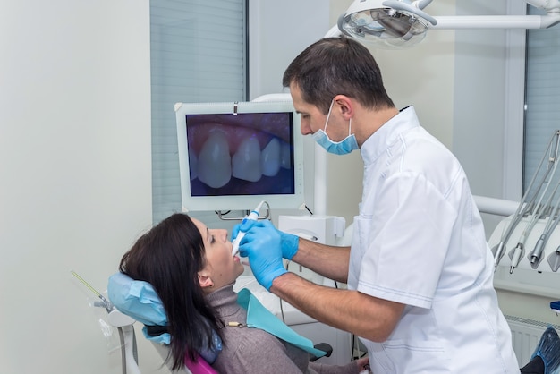 口腔病学の器具で患者の歯を治療する歯科医