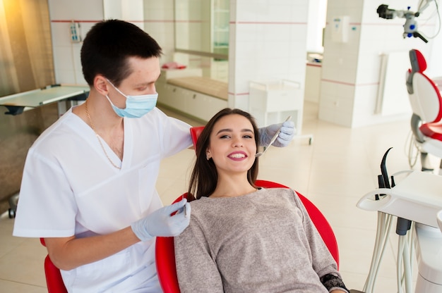 The dentist treating teeth of a beautiful woman