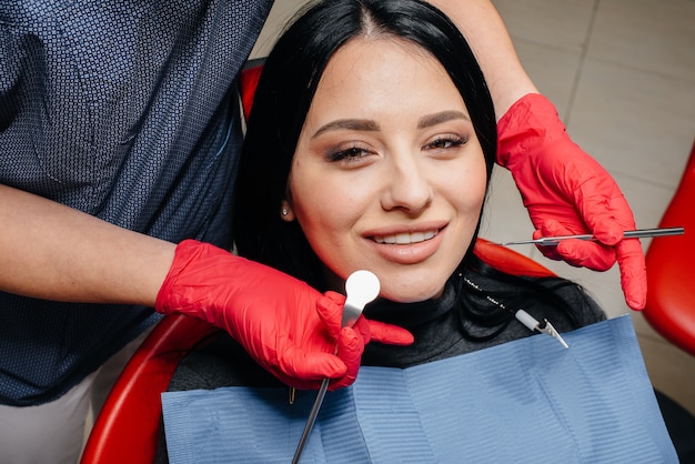 The dentist treats the girl's teeth to the patient. Dentistry