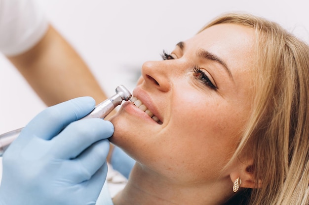 A dentist treats a woman's teeth in dental clinic