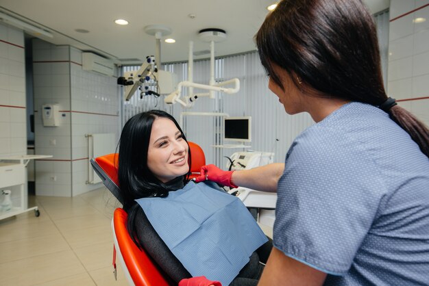 The dentist treats the woman teeth to the patient. Dentistry