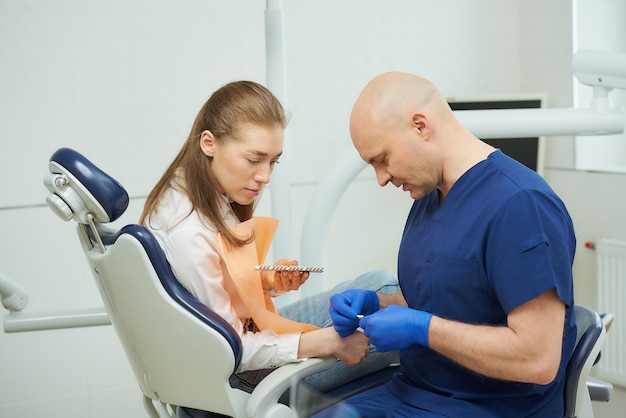 dentist in a uniform and disposable medical gloves with a patient in a dentist's office