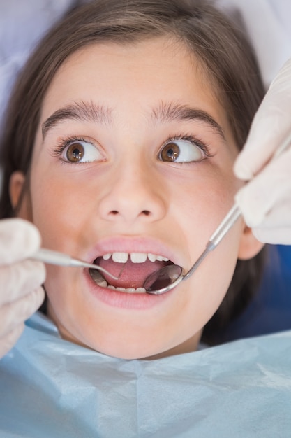 Dentist using dental explorer and angled mirror 