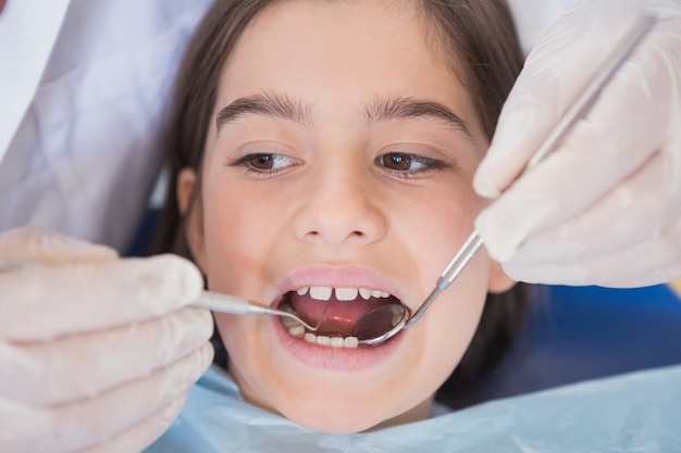 Dentist using dental explorer and angled mirror 