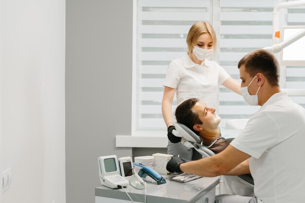 Dentist with an assistant work in a dental clinic.