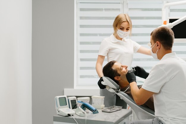 Dentist with an assistant work in a dental clinic.