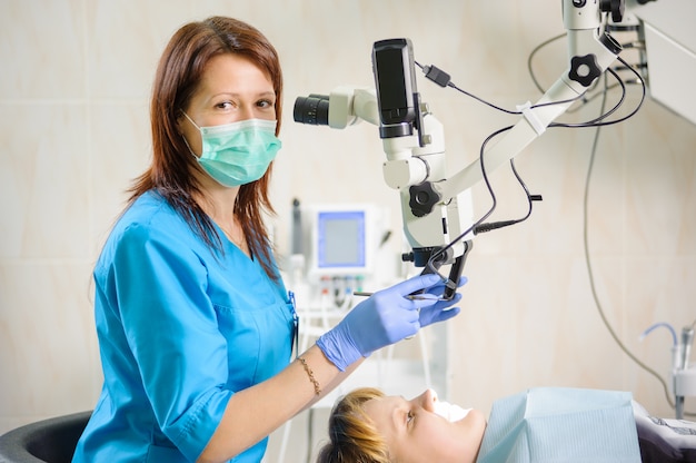 Dentist working with microscope at modern dental office