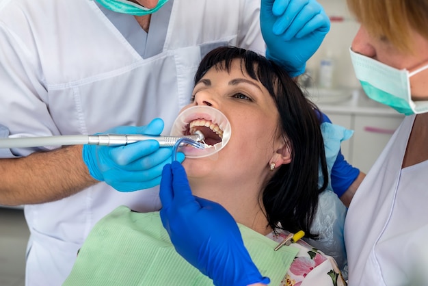 Dentista che lavora con il paziente in poltrona, odontoiatria