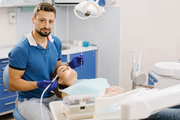 Дантист работая с пациентом с зубоврачебной дрелью
