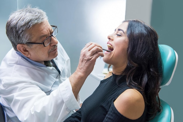 dentist at workplace examining patient female in dental chair highly qualified stomatologist