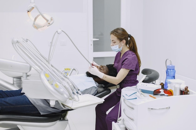 A dentist works with a patient in a dental office.