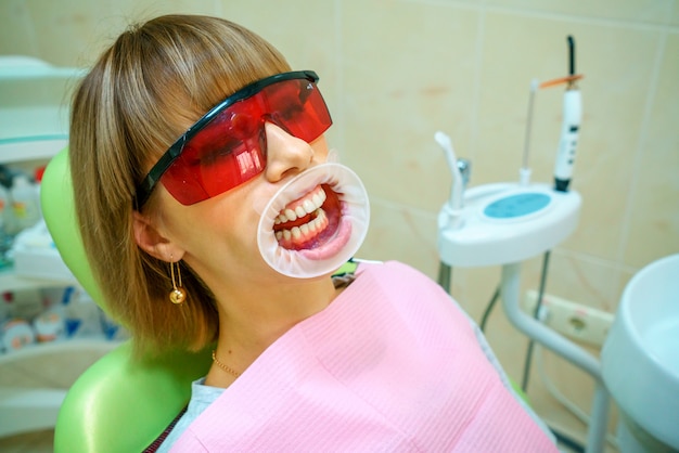 Dentistry happy patient in the chair in goggles.