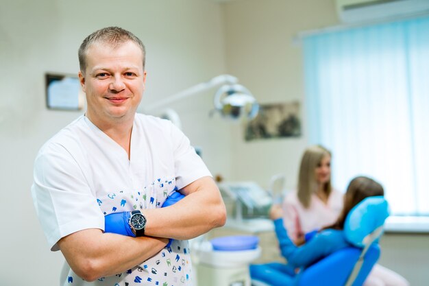 치과, 의학, 의료 장비 및 구강학 개념 - 의자가 있는 새로운 현대 치과 진료소 내부. 앞의 치과 의사.