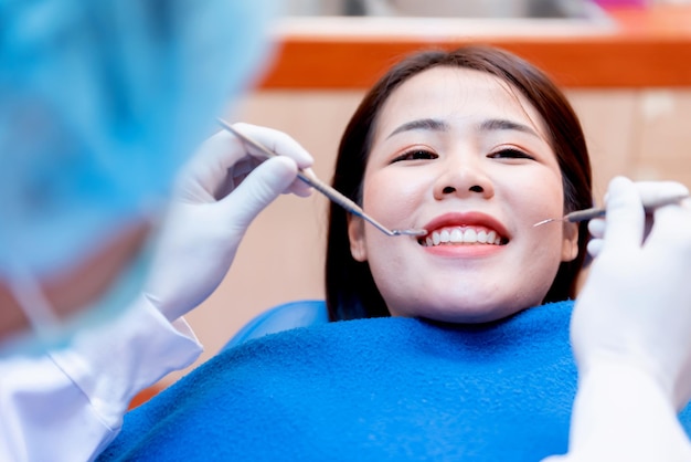 Dentistry and teeth healthcare concept at dental clinic. Dentist check-up teeth for young asian patient.