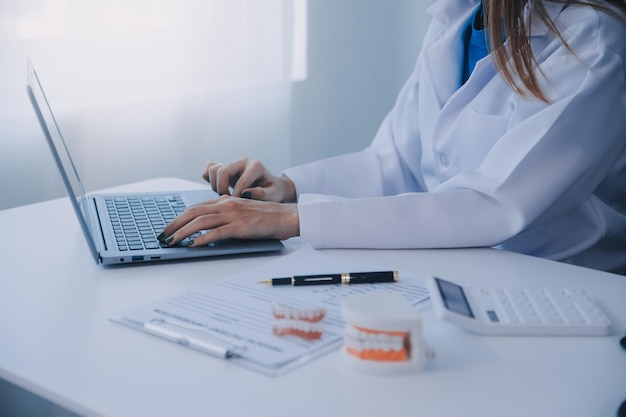 Dentists are discussing dental problems at report xray image on laptop screen to patients